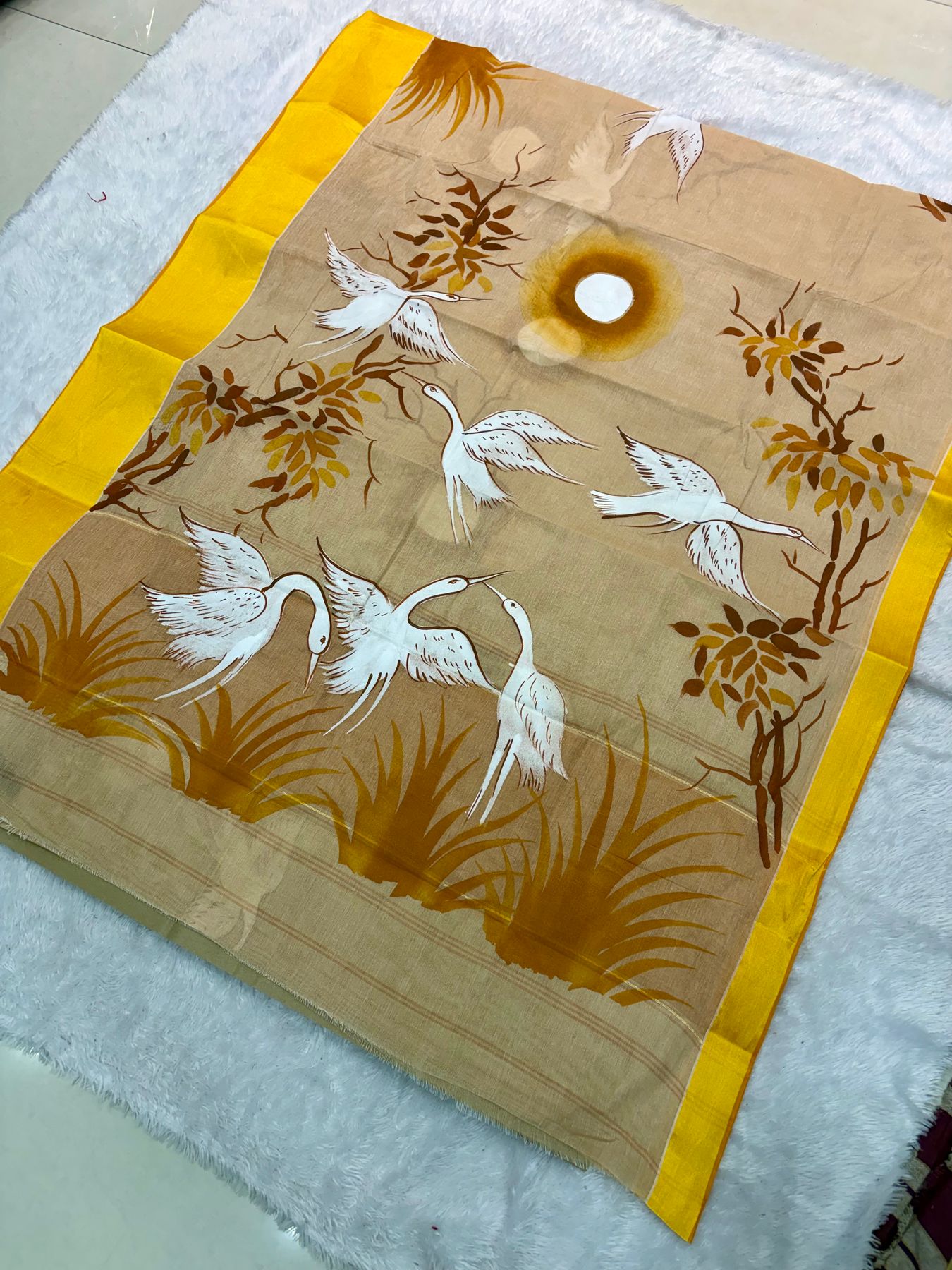 Hand-painted saree with white cranes flying over reeds